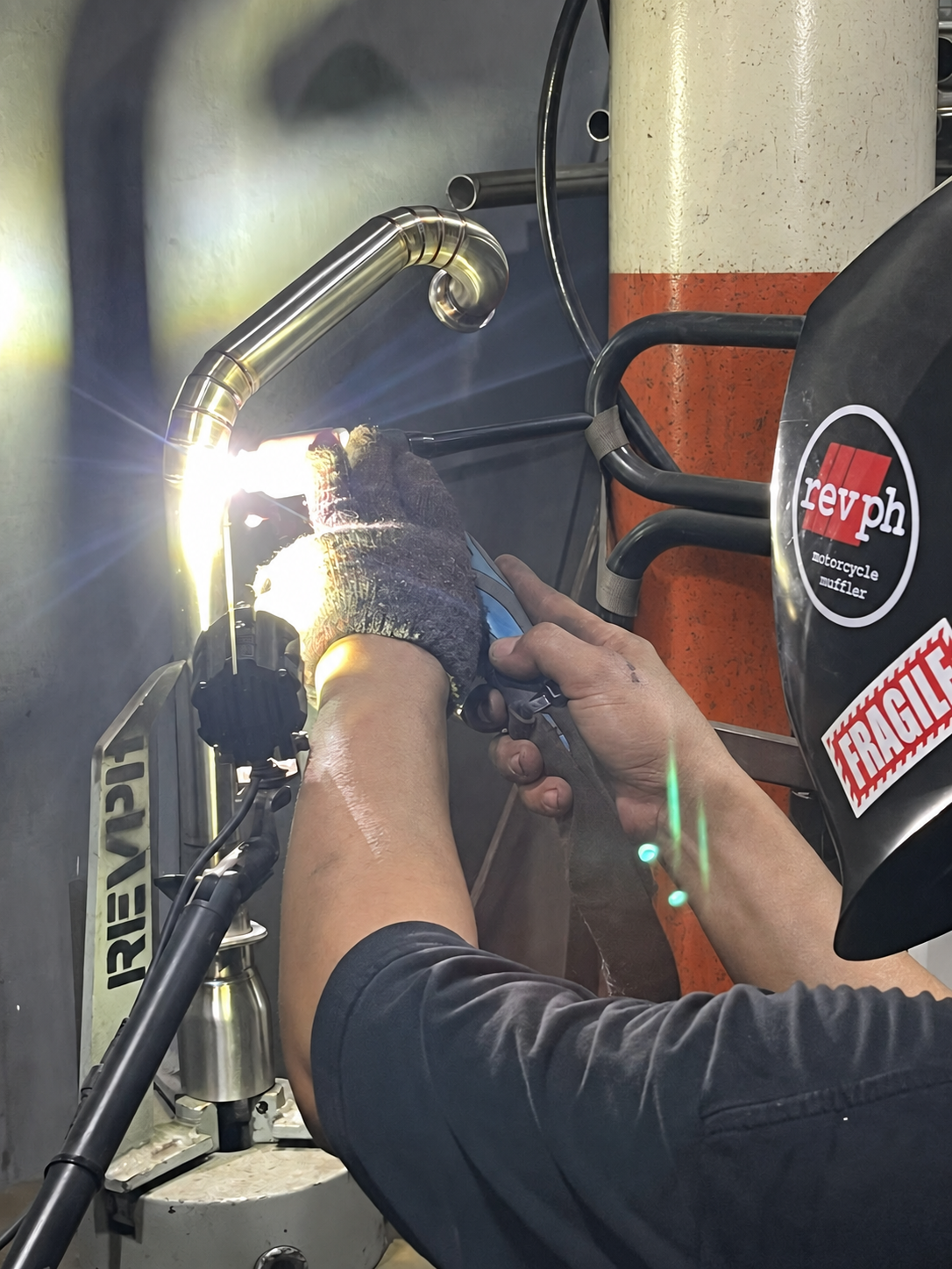 RevPH craftsman welding a handmade exhaust component