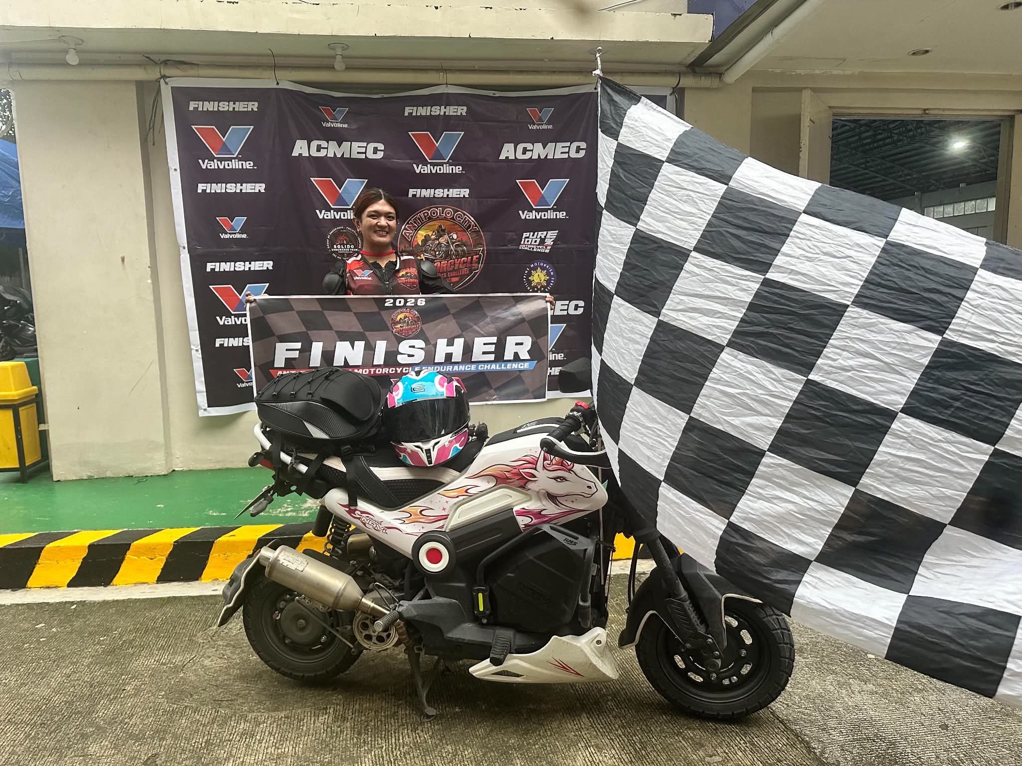 Motorcycle endurance challenge finisher with motorcycle and checkered flag